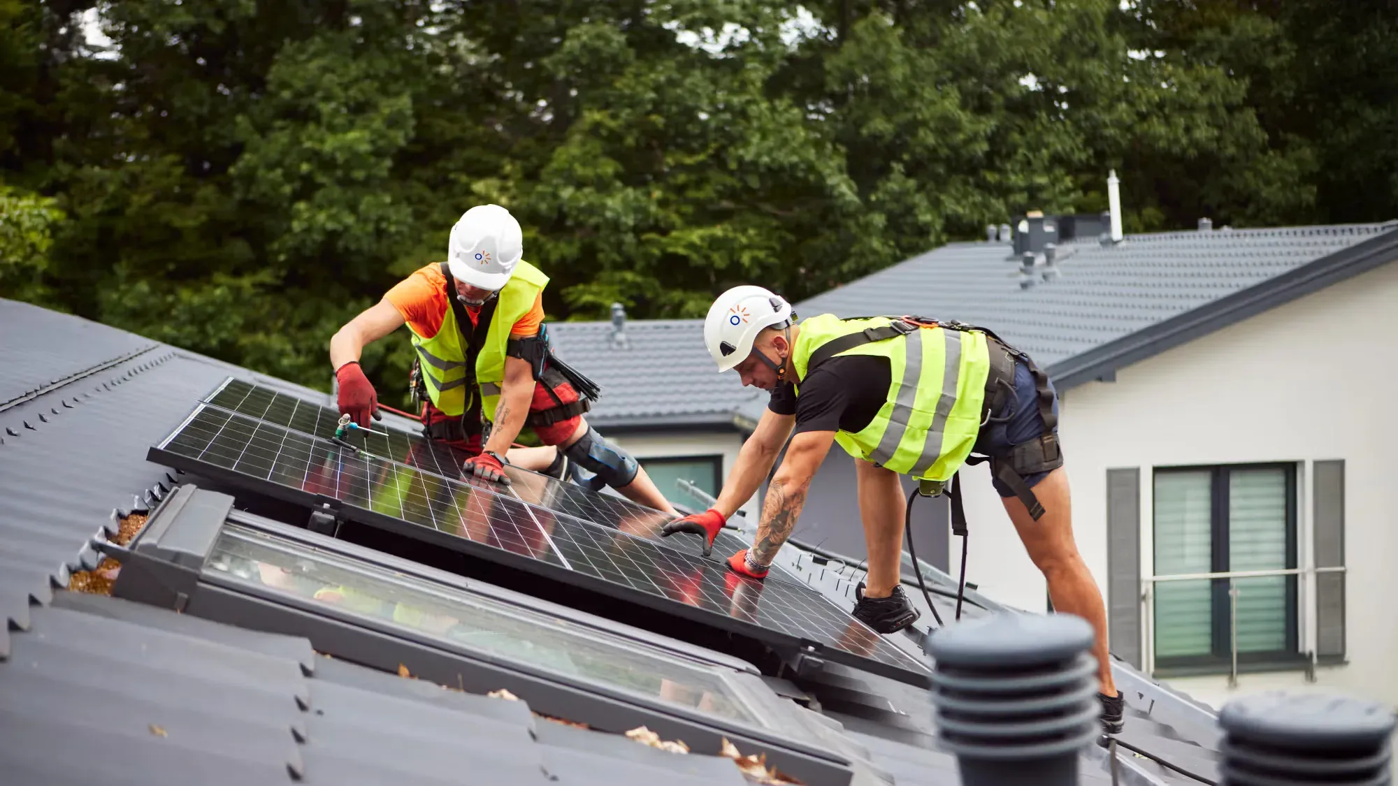 Twee installateurs die zonnepanelen op een dak monteren